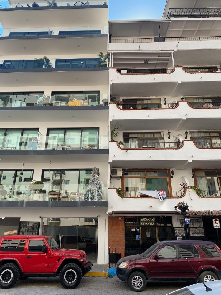 Apartment balconies above a street with a red pickup truck, Puerto Vallarta