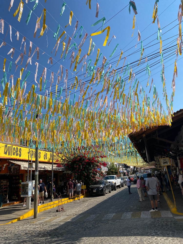 Papel picado banners strung above a busy market street, Puerto Vallarta