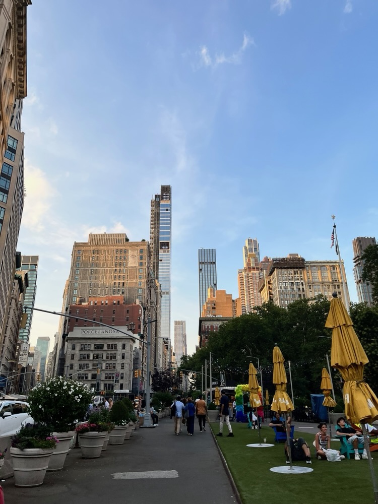 Flatiron building above the plaza with yellow market umbrellas, New York