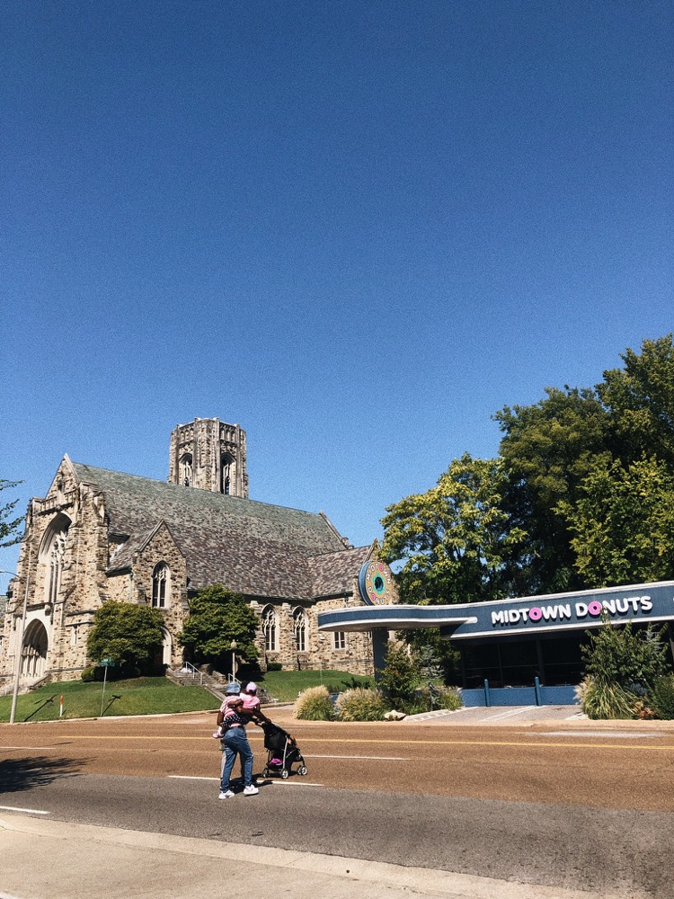 A stone church across a wide road from a donut shop, Memphis