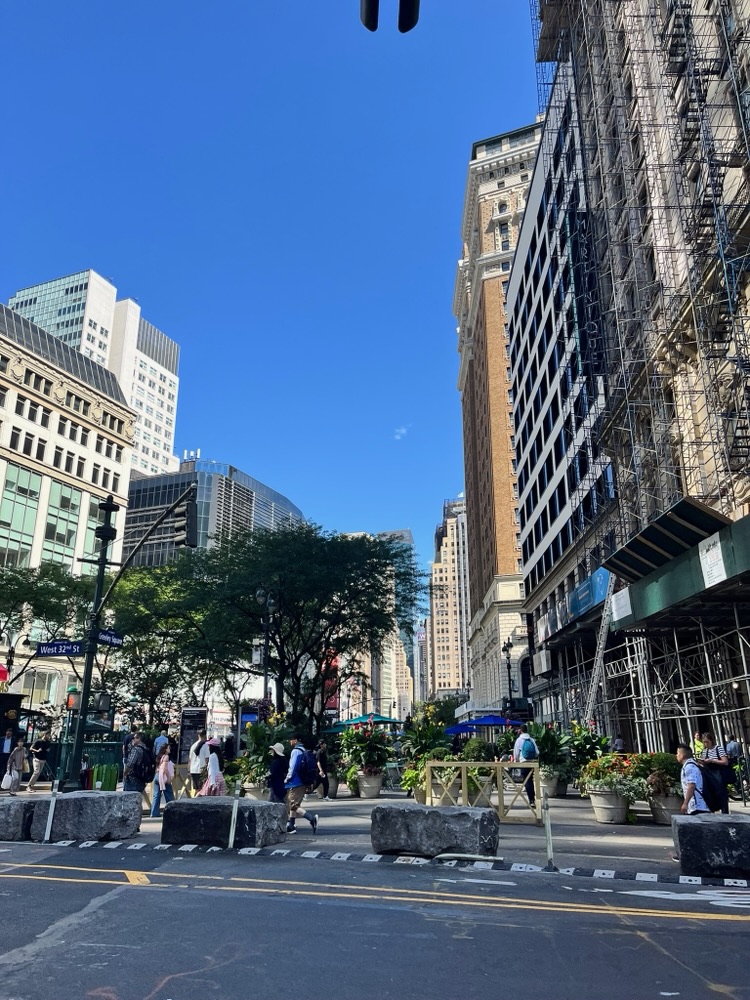 Midtown Manhattan street with stone planters and scaffolding