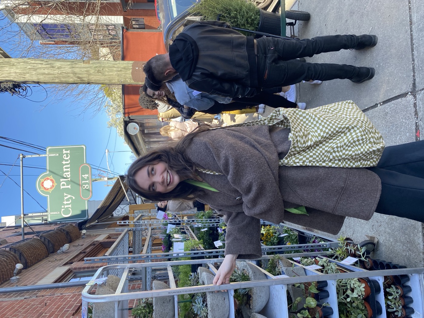 Ellie browsing plants outside City Planter, a city plant shop